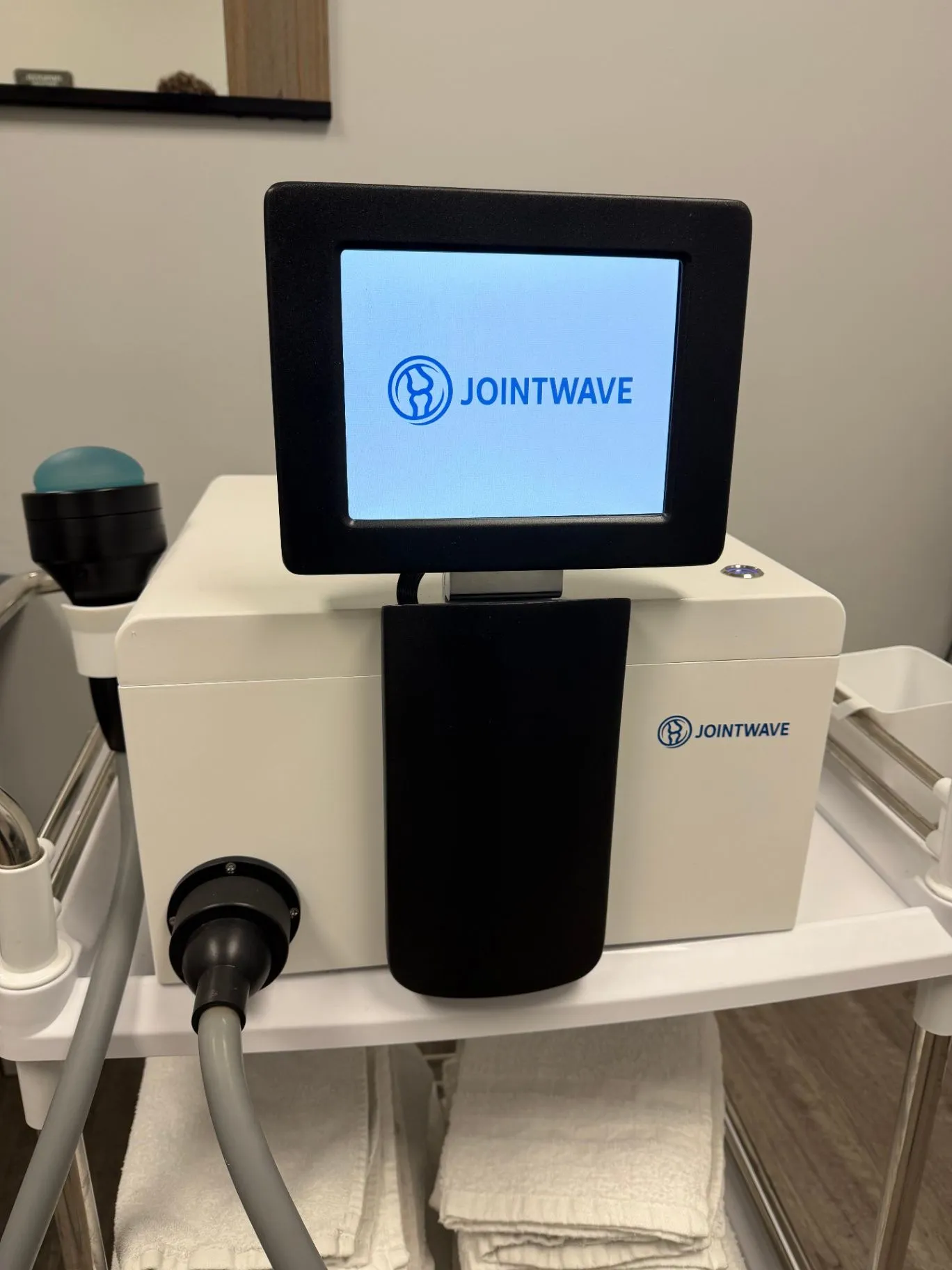 JointWave therapy system with its blue touchscreen visible