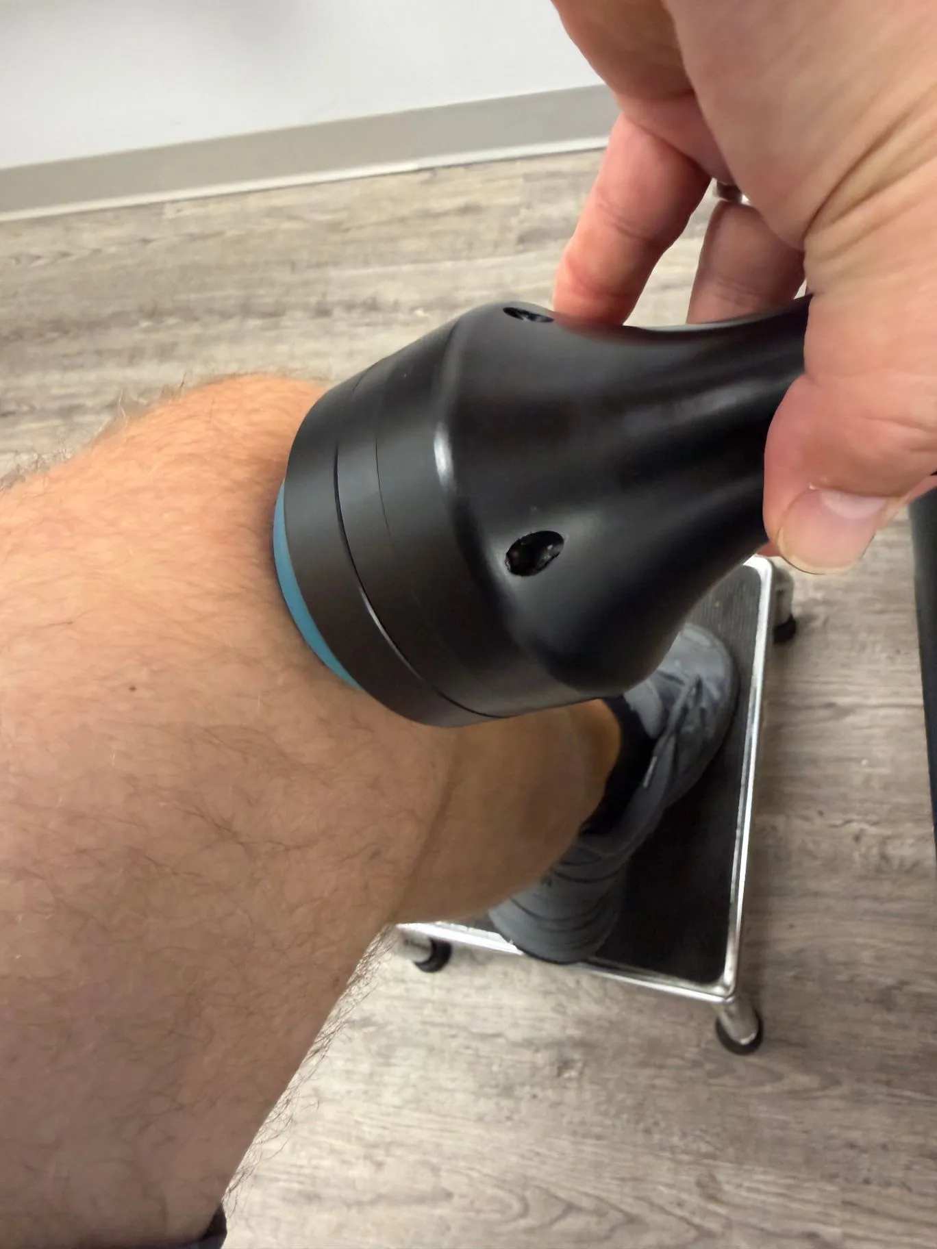JointWave handpiece being used on a patient's lower leg in a clinic