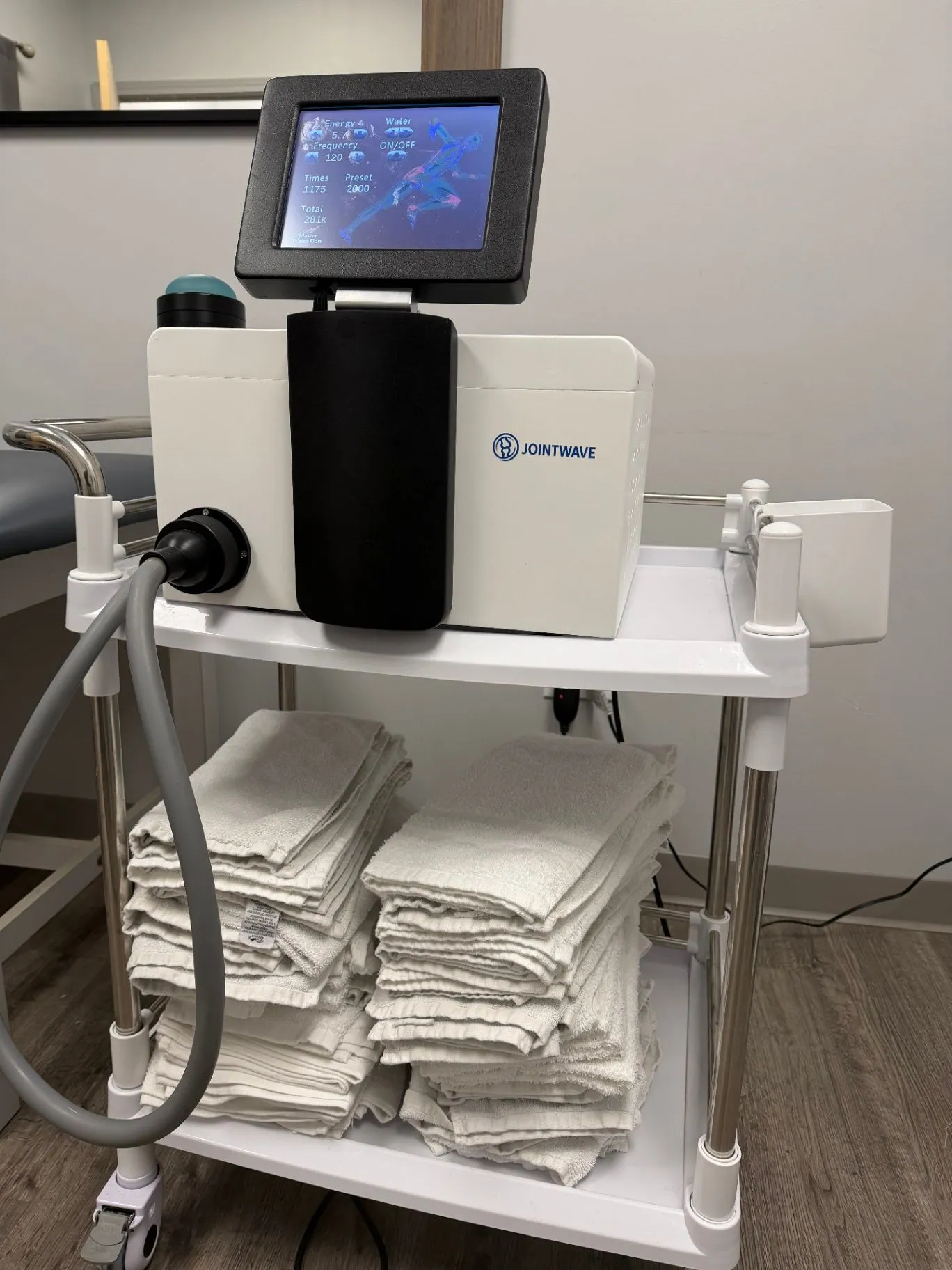 JointWave shockwave therapy system positioned on its cart in a treatment room